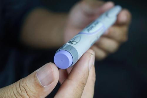 Closeup of a male hands holding insulin pen - Medical equipment concept